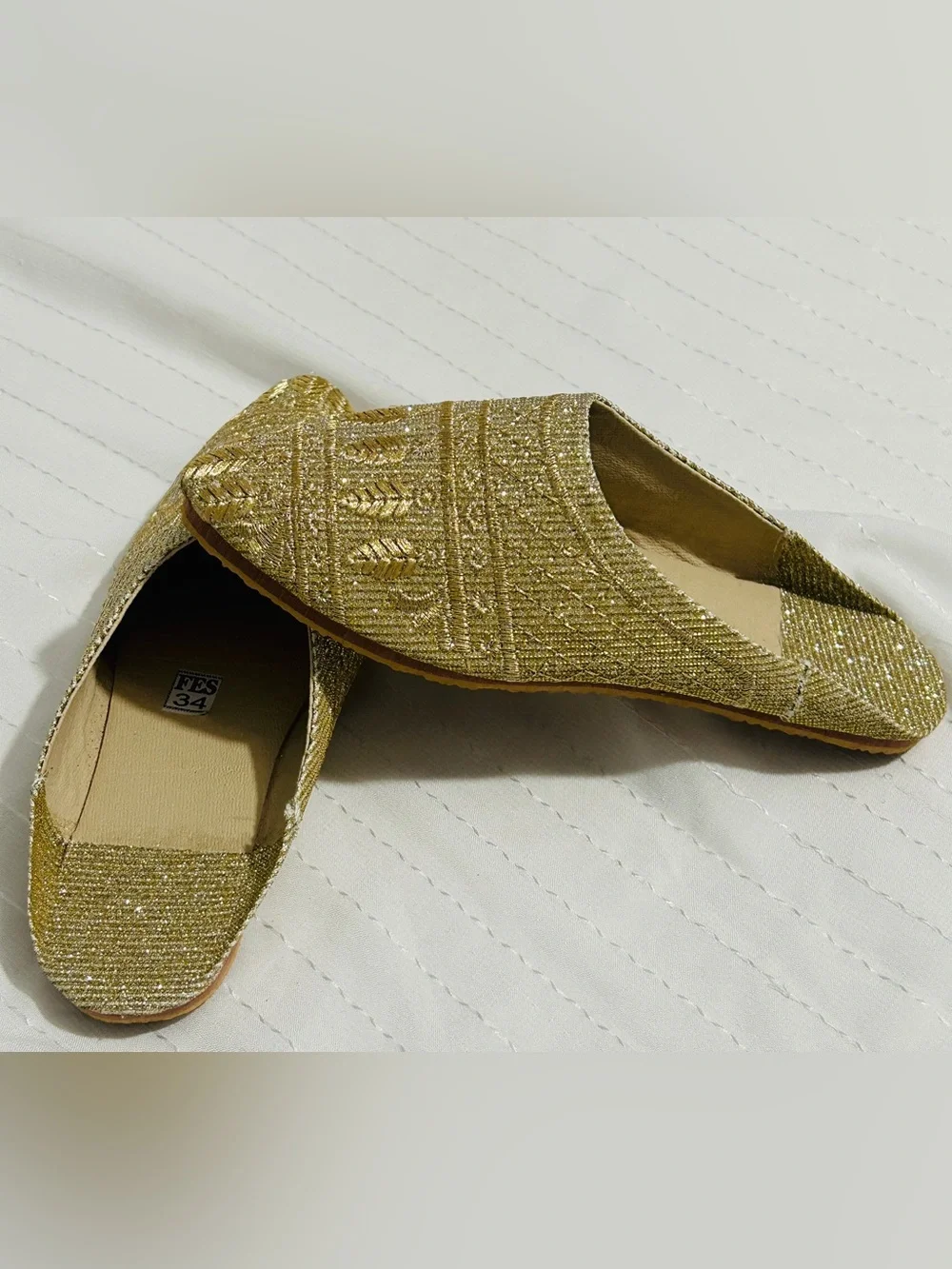 Moroccan babouche slippers adorned with intricate embroidery and a pointed toe.